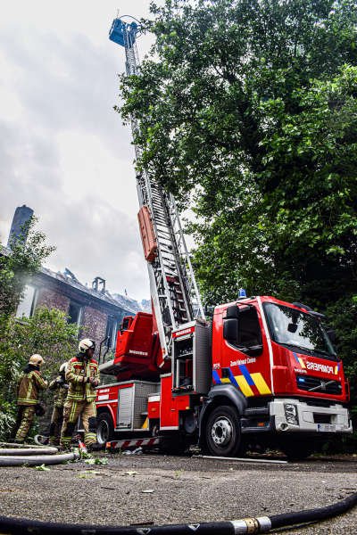 Pompiers et camion à échelle en intervention devant un bâtiment
