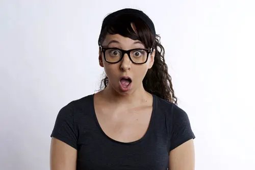 Jeune femme à lunettes, bouche ouverte, l'air stupéfait