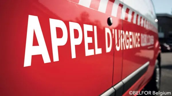 Flanc d'une camionnette rouge d'intervention marquée « Appel d'urgence »